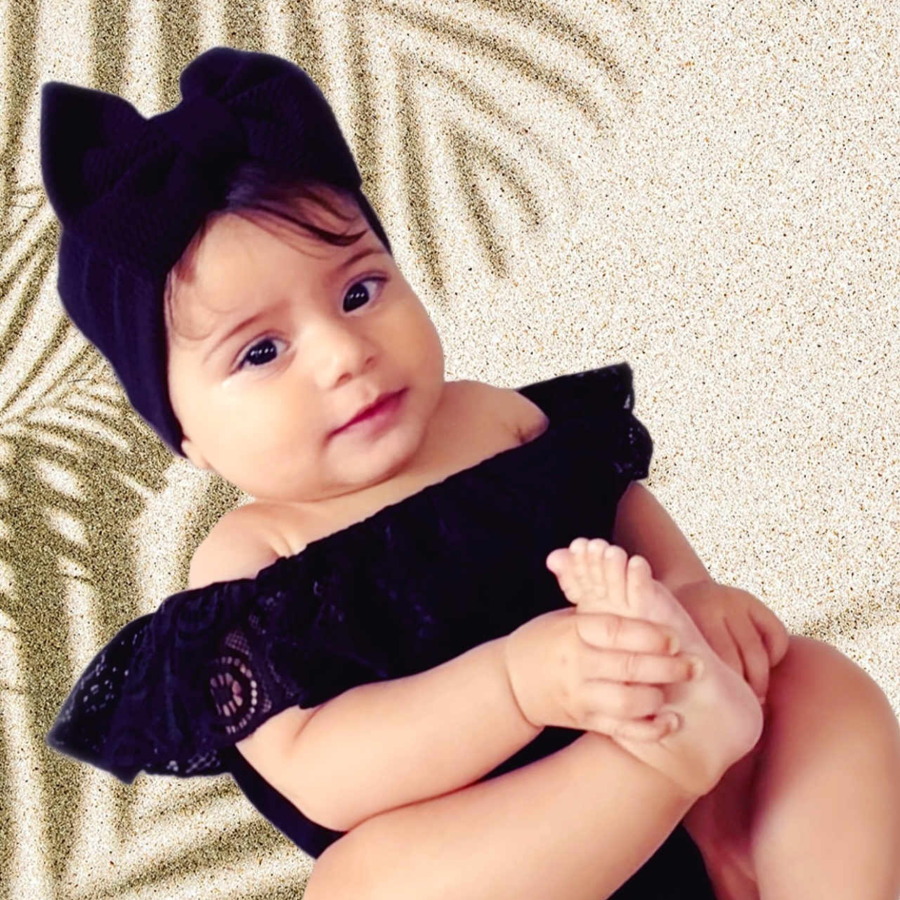 Milenna is registered to the contest to win money with this photo: baby, background, black_clothing, child, closeup, cute, fashion, foot, hand, headband, indoors, infant, person, playful, portrait, sitting, skin, smile, soft_light, toddler