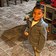 Adrian joined the competition — help win amazing prizes! child, boy, smiling, portrait, standing, indoors, playroom, toys, toy_shelf, toy_car, colorful_toys, floor_tiles, jacket, pants, shoes, short_hair, happy, home, room, photography