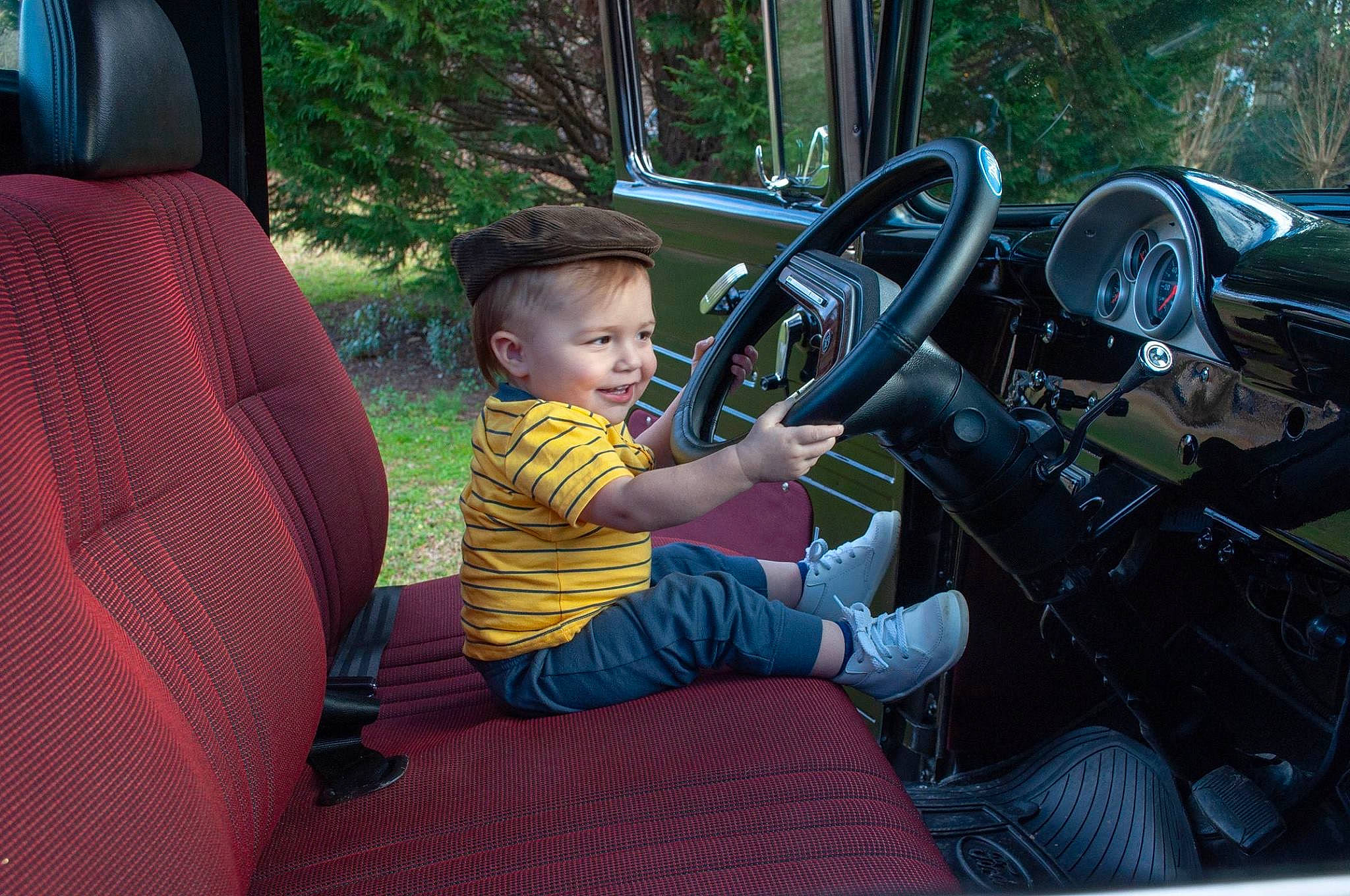 Maddox is registered to the contest to win money with this photo: automotive_exterior, car, driving, family_car, motor_vehicle, person, plant, steering_part, steering_wheel, subcompact_car, vehicle