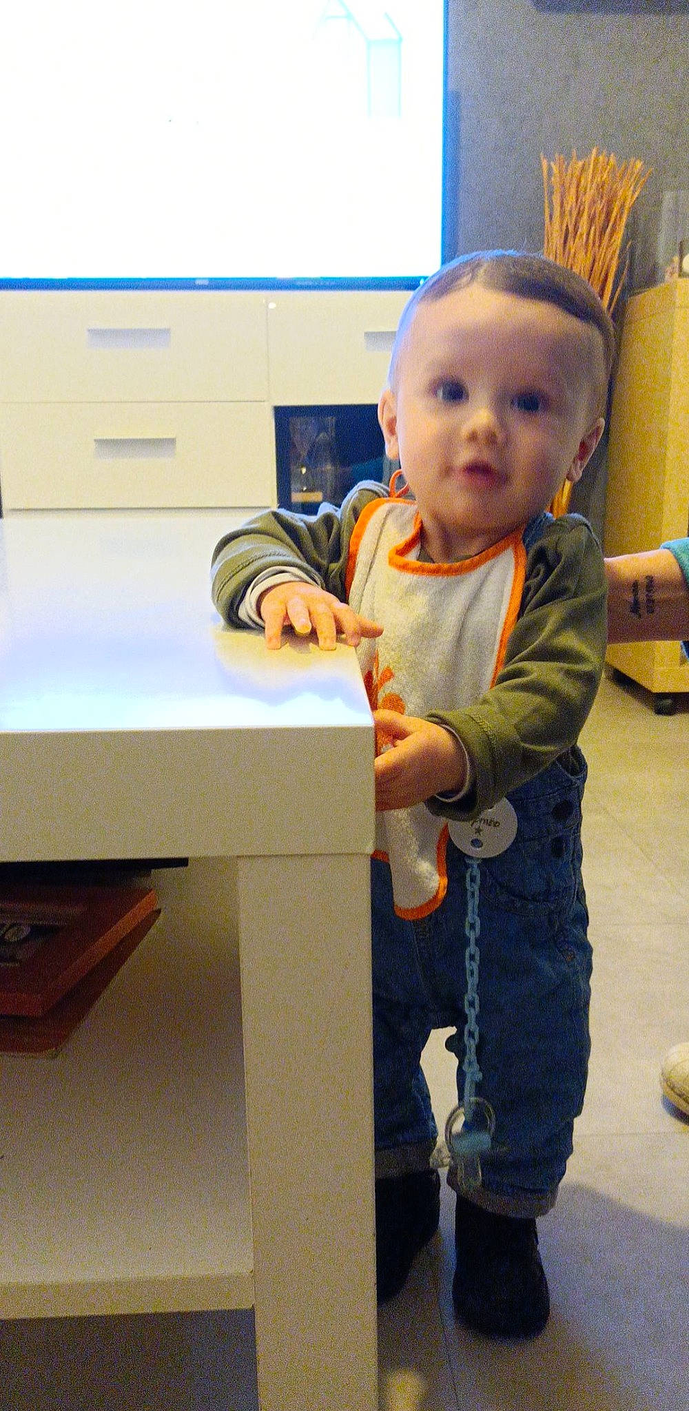 Tymëo participe au concours pour gagner de l'argent avec cette photo : baby, baby_toddler_clothing, cabinetry, chest_of_drawers, child, desk, drawer, dresser, flooring, fun, person, play, room, sitting, sleeve, standing, t_shirt, table, thumb, toddler