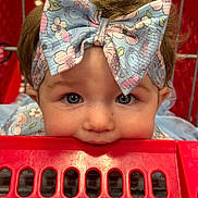 Kamilah is registered to the contest to win money with this photo: accessory, baby, blue_eyes, bow, child, closeup, clothing, cute, face, fashion, happy, headband, indoor, infant, person, playful, portrait, red, shopping_cart, toddler