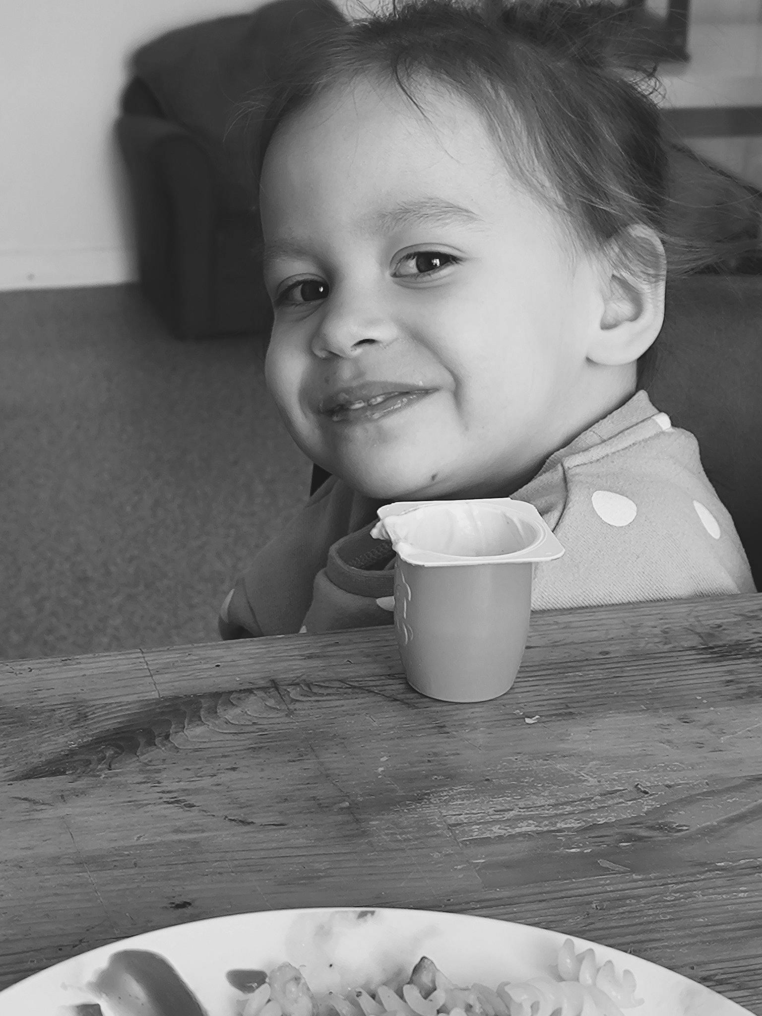 Hina participe au concours pour gagner de l'argent avec cette photo : baby, black, black_and_white, drinkware, face, food, fun, hairstyle, head, joy, monochrome, monochrome_photography, mouth, person, photograph, smile, standing, style, table, tableware