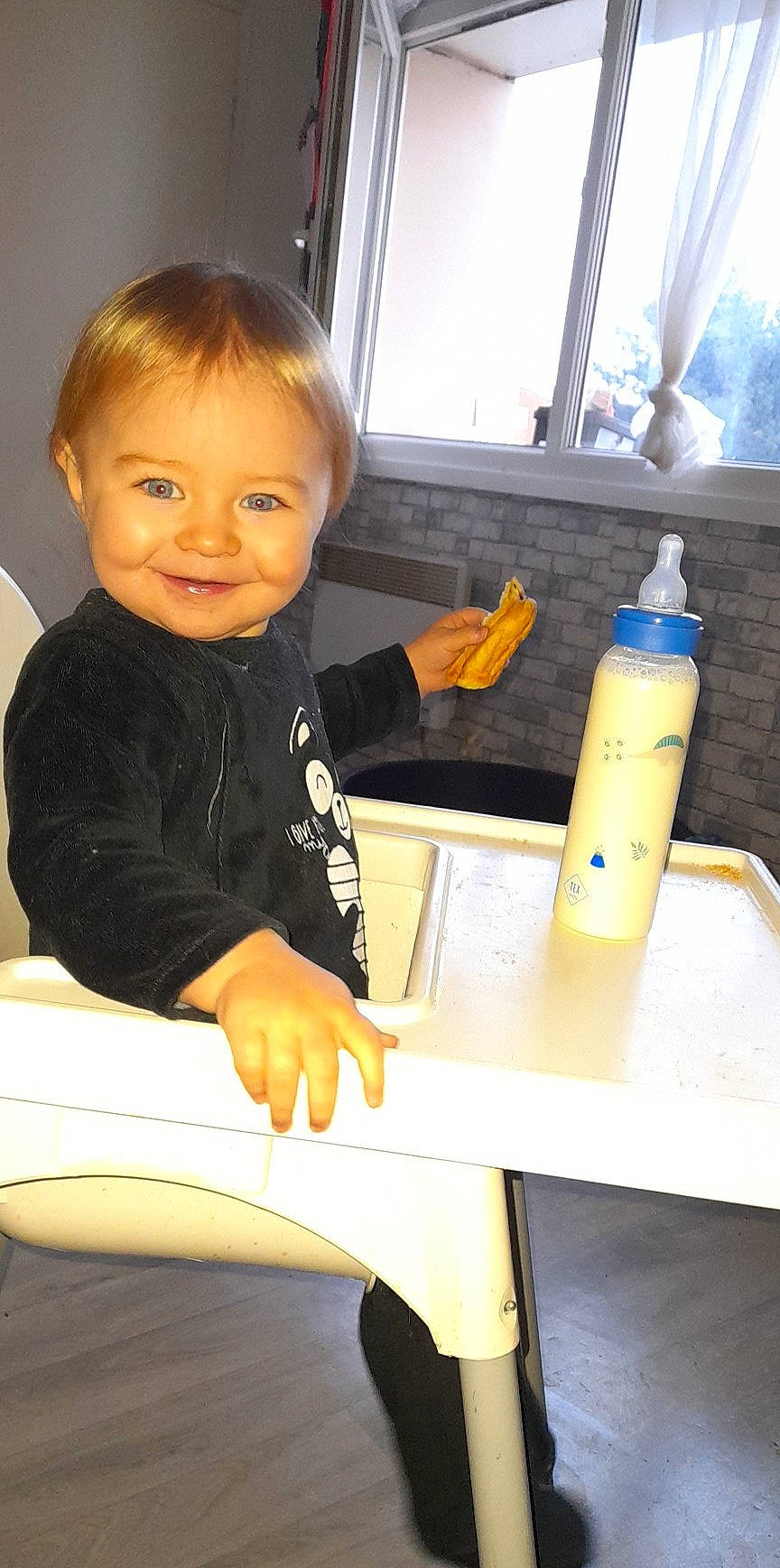 Amaël participe au concours pour gagner de l'argent avec cette photo : baby, baby_toddler_clothing, chair, child, finger, fun, hand, joy, person, product, room, sitting, sleeve, smile, standing, t_shirt, table, thigh, thumb, toddler