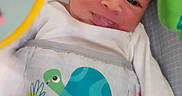 Mateo is registered to the contest to win money with this photo: baby, baby_chair, child, clothing, colorful, cute, face, happy, head, indoor, infant, onesie, pattern, person, playful, skin, smile, toy, turtle, young_child