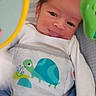Mateo is registered to the contest to win money with this photo: baby, infant, child, onesie, turtle, baby_chair, toy, colorful, cute, smile, face, clothing, indoor, young_child, playful, pattern, happy, person, skin, head