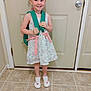 Hermonie is registered to the contest to win money with this photo: child, girl, pigtails, backpack, floral_dress, smile, standing, indoor, door, floor_tiles, shoes, pink_ribbons, white_shoes, happy, young, person, cute, ready, casual, home