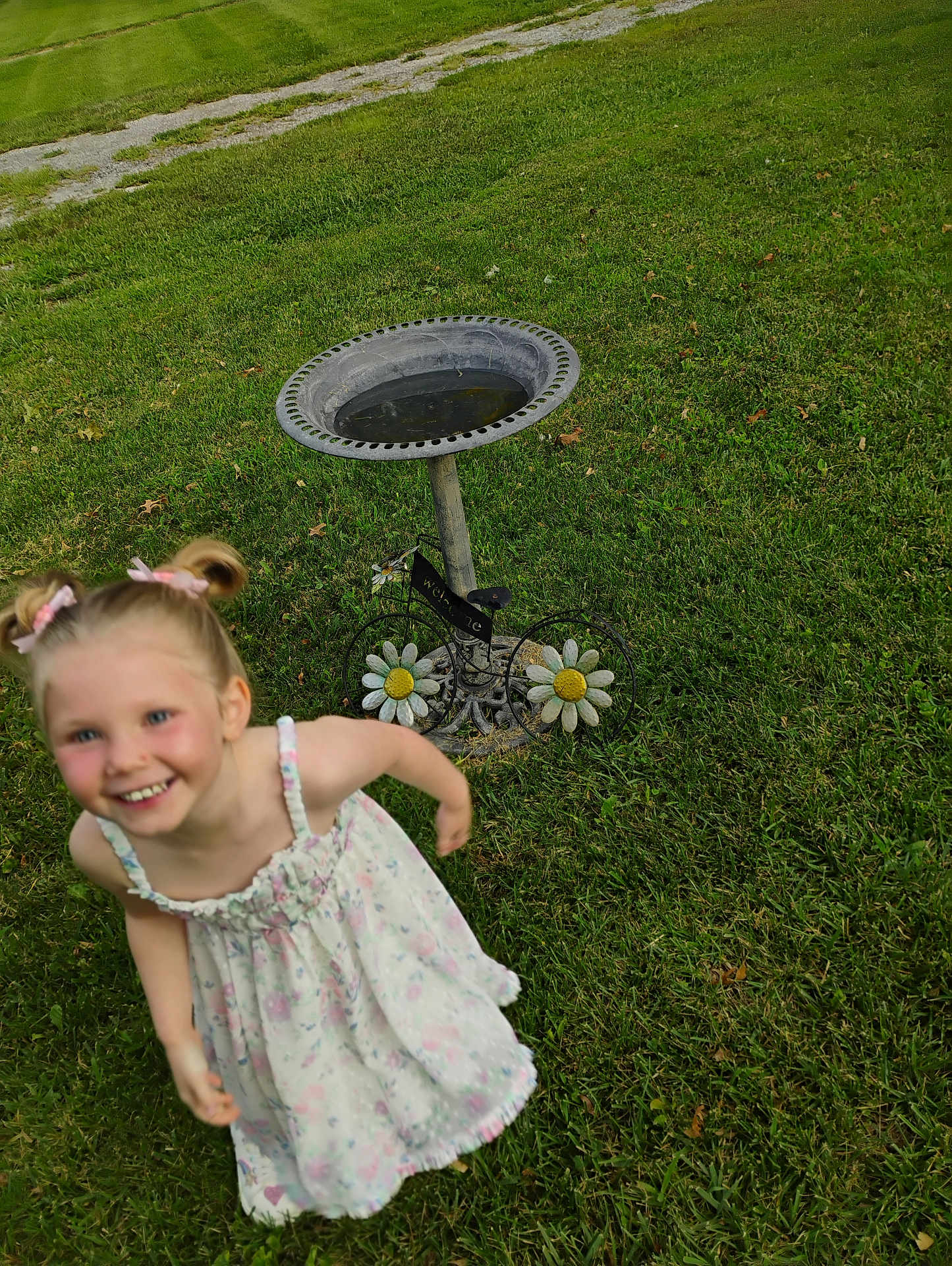 Hermonie joined the competition — help win amazing prizes! child, smiling, girl, pigtails, dress, flower_pattern, grass, birdbath, decorative, outdoor, daylight, greenery, happy, playful, nature, summer, welcome_sign, pathway, metal, garden