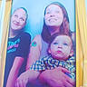 child, adult, photo_booth, portrait, smile, tattoo, plaid_shirt, cartoon_character, family, indoor, casual_clothing, happy, people, group, blue_background, yellow_frame, chuck_e_cheese, holding, looking_up, fun