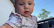 Linley is registered to the contest to win money with this photo: baby, child, outdoor, sky, onesie, floral_pattern, building, can, drink, curious, sitting, person, daylight, blue_sky, expression, face, head, arm, leg, tree
