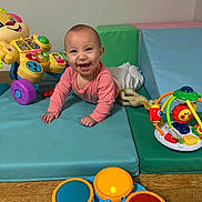 Linley joined the competition — help win amazing prizes! baby, infant, crawling, pink_clothing, playmat, toy, activity_walker, drum_toy, colorful, happy, smiling, indoor, child, floor, wood_floor, play_area, early_childhood, cute, face, person
