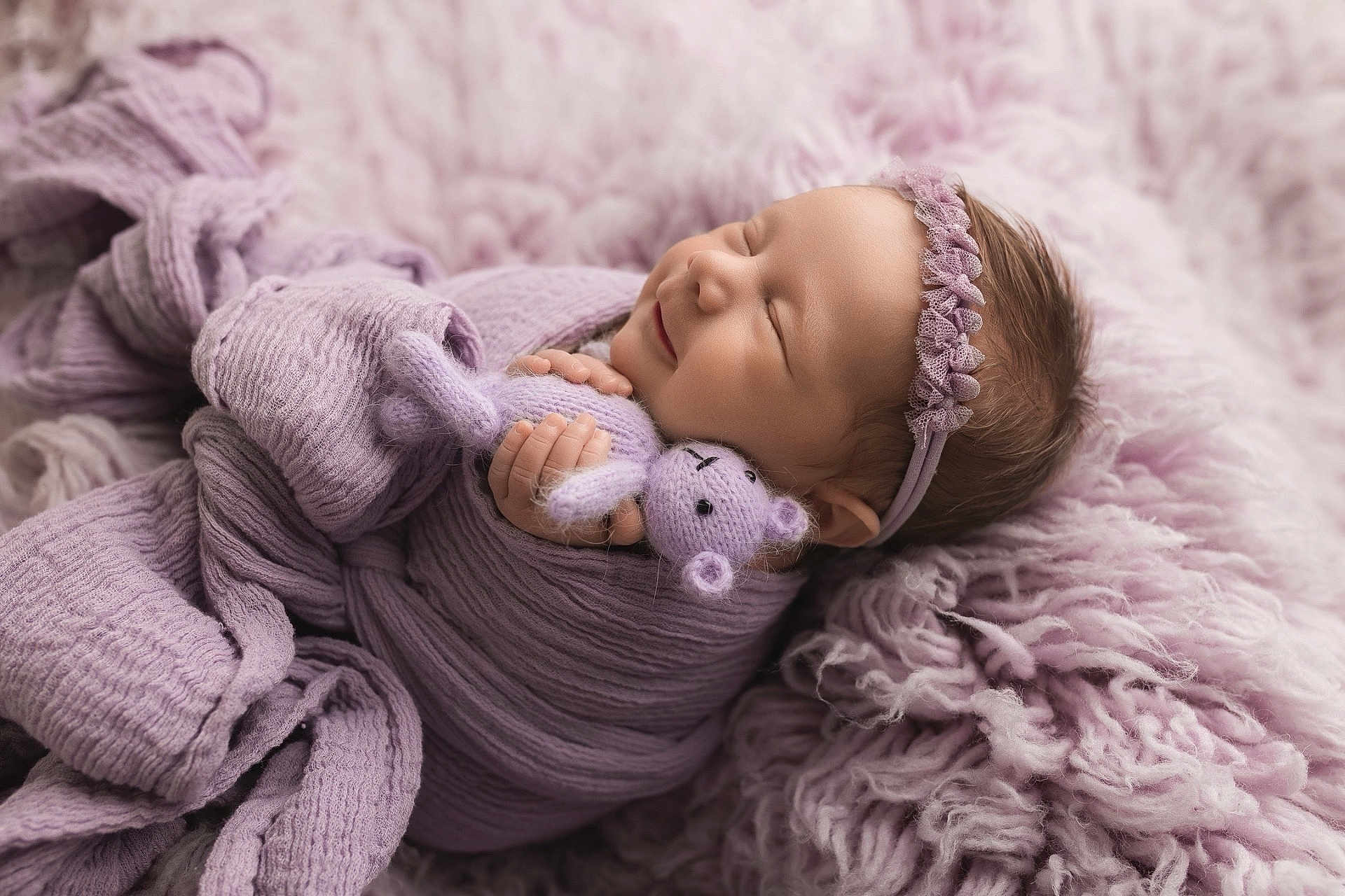 Lainey is registered to the contest to win money with this photo: newborn, baby, sleeping, lavender, blanket, knitted_toy, headband, soft_texture, cozy, wrapped, infant, cute, peaceful, portrait, child, purple, fuzzy, resting, hand, smile