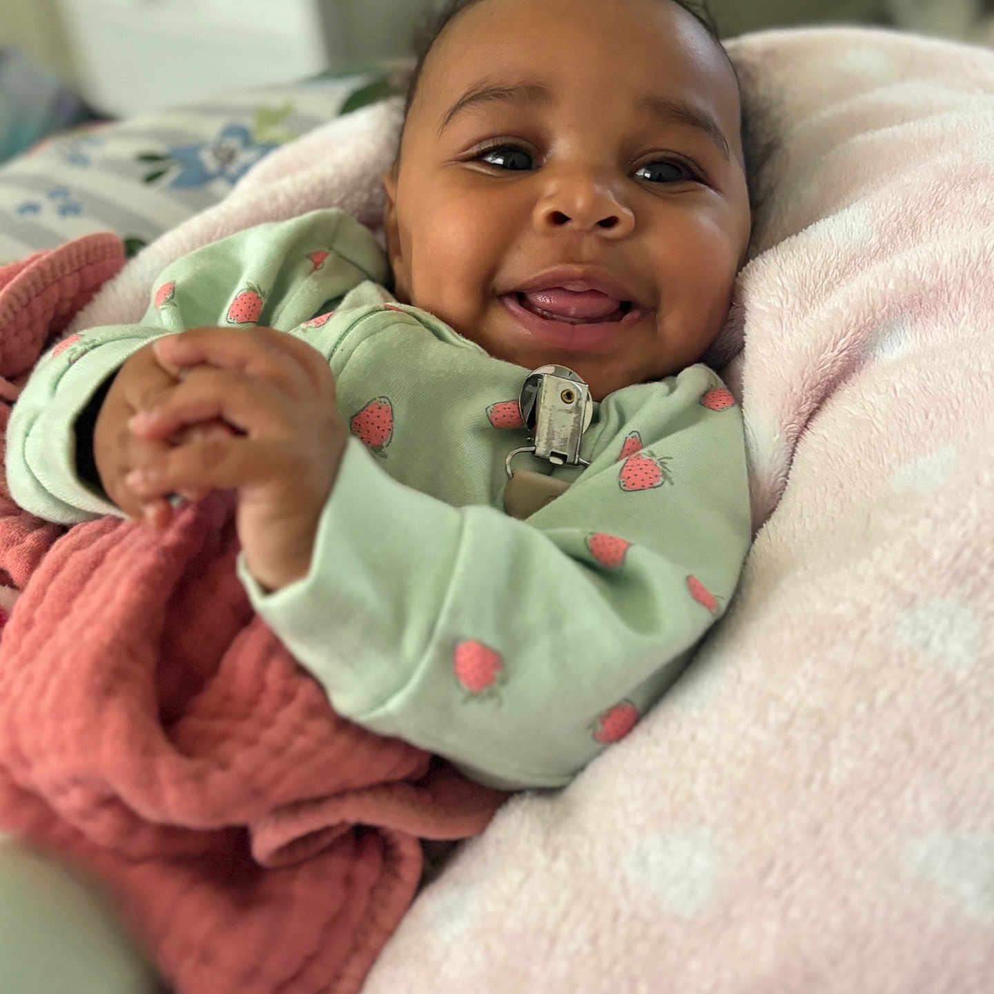 Tyleah joined the competition — help win amazing prizes! baby, bed, blanket, child, clothing, comfort, cozy, cute, cute_baby, face, hand, happy, indoors, infant, lying_down, playful, portrait, smiling, soft_texture, strawberry_print