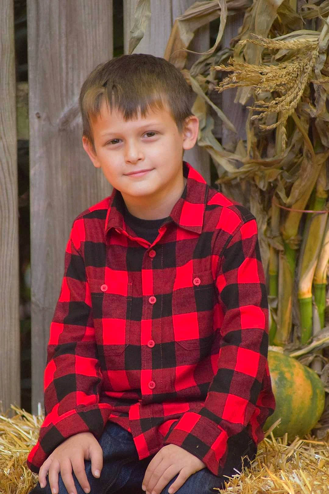 Jayden is registered to the contest to win money with this photo: child, fur, grass, happy, human, joy, leaf, natural_foods, outerwear, pattern, people_in_nature, person, plaid, plant, portrait_photography, sitting, sleeve, smile, soil, tartan