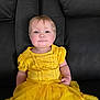 Amelia joined the competition — help win amazing prizes! toddler, child, yellow_dress, smiling, blue_eyes, sitting, leather_couch, indoor, portrait, cute, young_child, happy, fashion, girl, clothing, person, casual, baby, front_view, one_person
