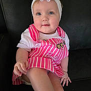 Amelia joined the competition — help win amazing prizes! baby, child, girl, headband, flower, pink_dress, striped_clothing, barbie, blue_eyes, couch, black_leather, sitting, innocence, cute, portrait, hand, legs, white_shirt, happy, indoor