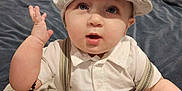 Jacob is registered to the contest to win money with this photo: accessories, baby, baseballcap, bed, bodypart, cap, clothing, couch, face, finger, furniture, hand, hat, head, indoors, pants, person, photography, portrait, sitting