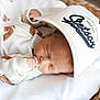 Stetson-Alan joined the competition — help win amazing prizes! newborn, baby, sleeping, hat, cap, basket, cozy, white_clothing, football_pattern, hand, infant, soft_light, indoors, peaceful, cute, portrait, resting, blanket, woven_basket, babywear