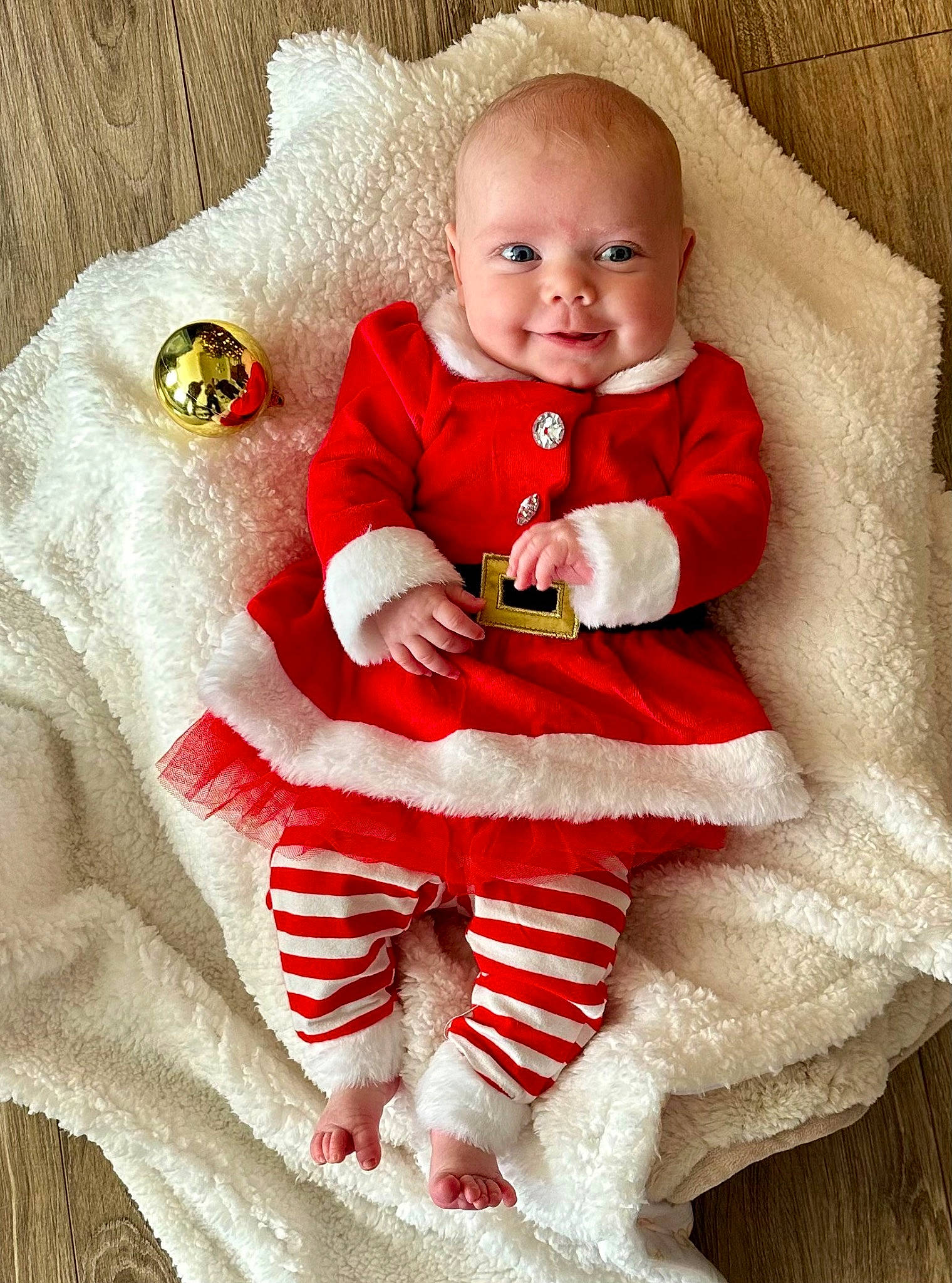 Lucy is registered to the contest to win money with this photo: baby, baby_toddler_clothing, child, christmas, christmas_eve, comfort, dress, event, face, happy, head, joy, pattern, person, red, sitting, skin, sleeve, smile, sock