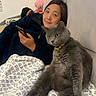 Blakey The Gray Cat joined the competition — help win amazing prizes! person, cat, sofa, blanket, indoor, relaxed, smartphone, window_blinds, gray_cat, patterned_blanket, casual_clothing, sitting, furniture, home, pet, companion, looking_at_camera, cozy, resting, domestic