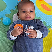 Heaven a rejoint le concours — aidez-le/la à gagner de superbes lots ! baby, child, infant, play_mat, colorful, toy_ball, orange_ball, blue_ball, clothing, laying_down, hands, face, curious, indoor, soft_texture, patterned_background, young_child, cute, portrait, casual