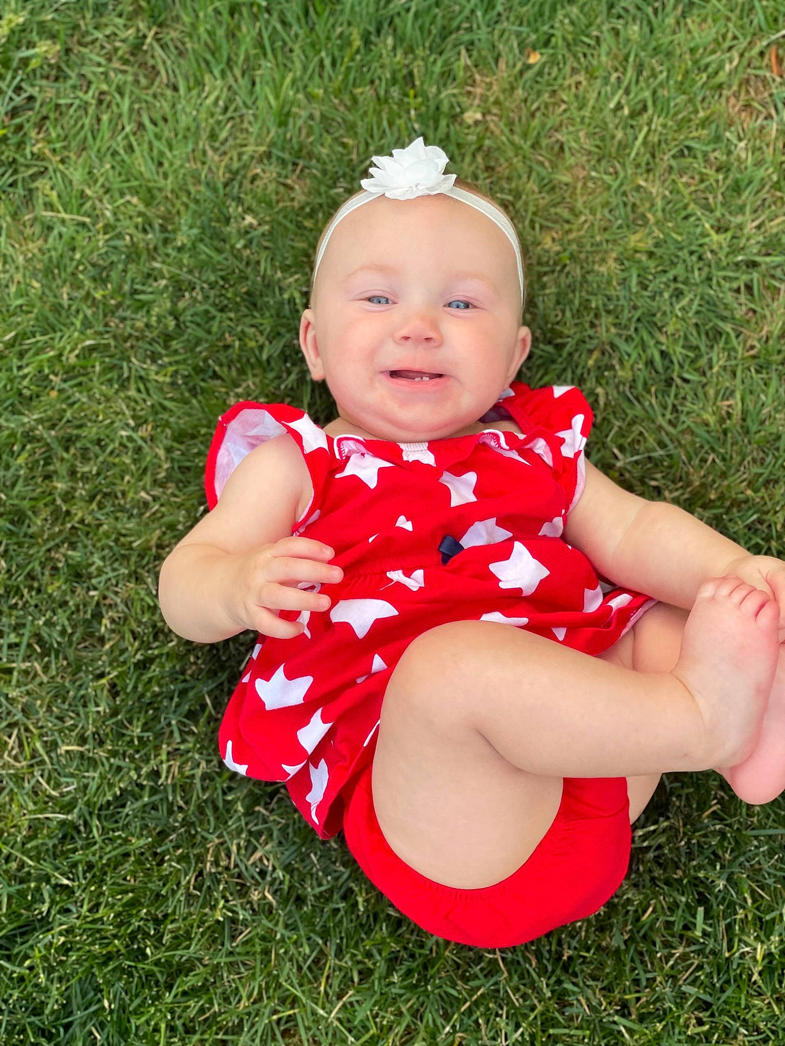 Aspen is registered to the contest to win money with this photo: baby, baby_toddler_clothing, child, eye, flash_photography, foot, fun, gesture, grass, happy, human_leg, leaf, meadow, pattern, people_in_nature, person, plant, sitting, smile, thigh