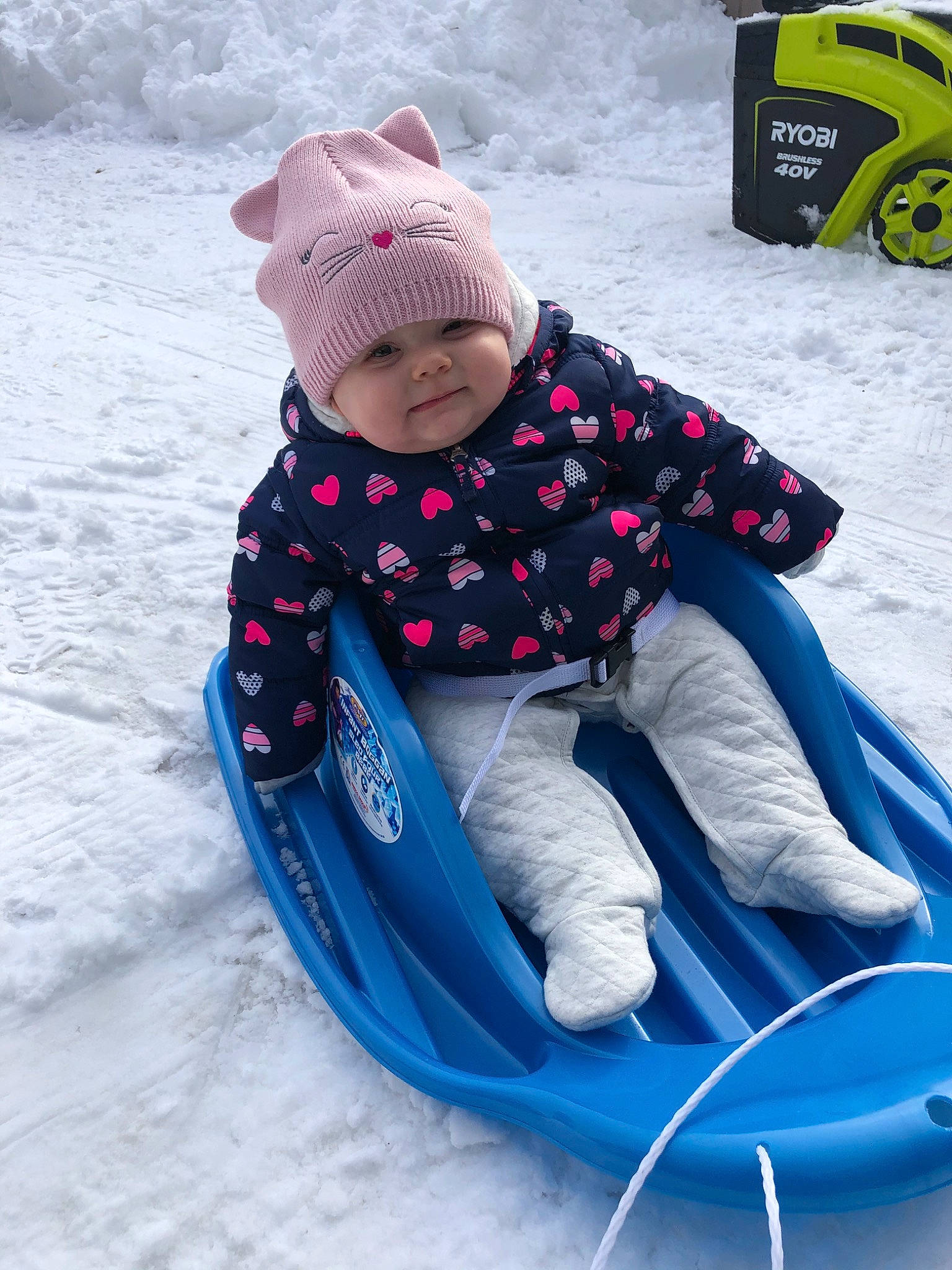 Kinzley is registered to the contest to win money with this photo: baby, beanie, child, fun, outerwear, person, play, playing_in_the_snow, recreation, sled, sledding, snow, toddler, vacation, vehicle, winter, winter_sport