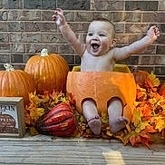 Eli joined the competition — help win amazing prizes! baby, pumpkin, fall, autumn, leaves, brick_wall, happy, smiling, child, seasonal, orange, cute, celebration, outdoor, decoration, festive, sitting, bare_chest, holiday, nature