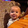 baby, casual, child, cute, expression, face, hair_ties, happy, indoor, person, playful, portrait, seat, smiling, snack, toddler, tongue_out, wooden_table, woven_chair, young_child