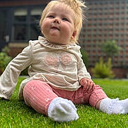 Martha is registered to the contest to win money with this photo: baby, child, grass, outdoor, cute, pink_pants, white_socks, blonde_hair, curious, sitting, portrait, nature, greenery, casual_clothing, toddler, young_child, happy, daylight, lawn, butterfly_design