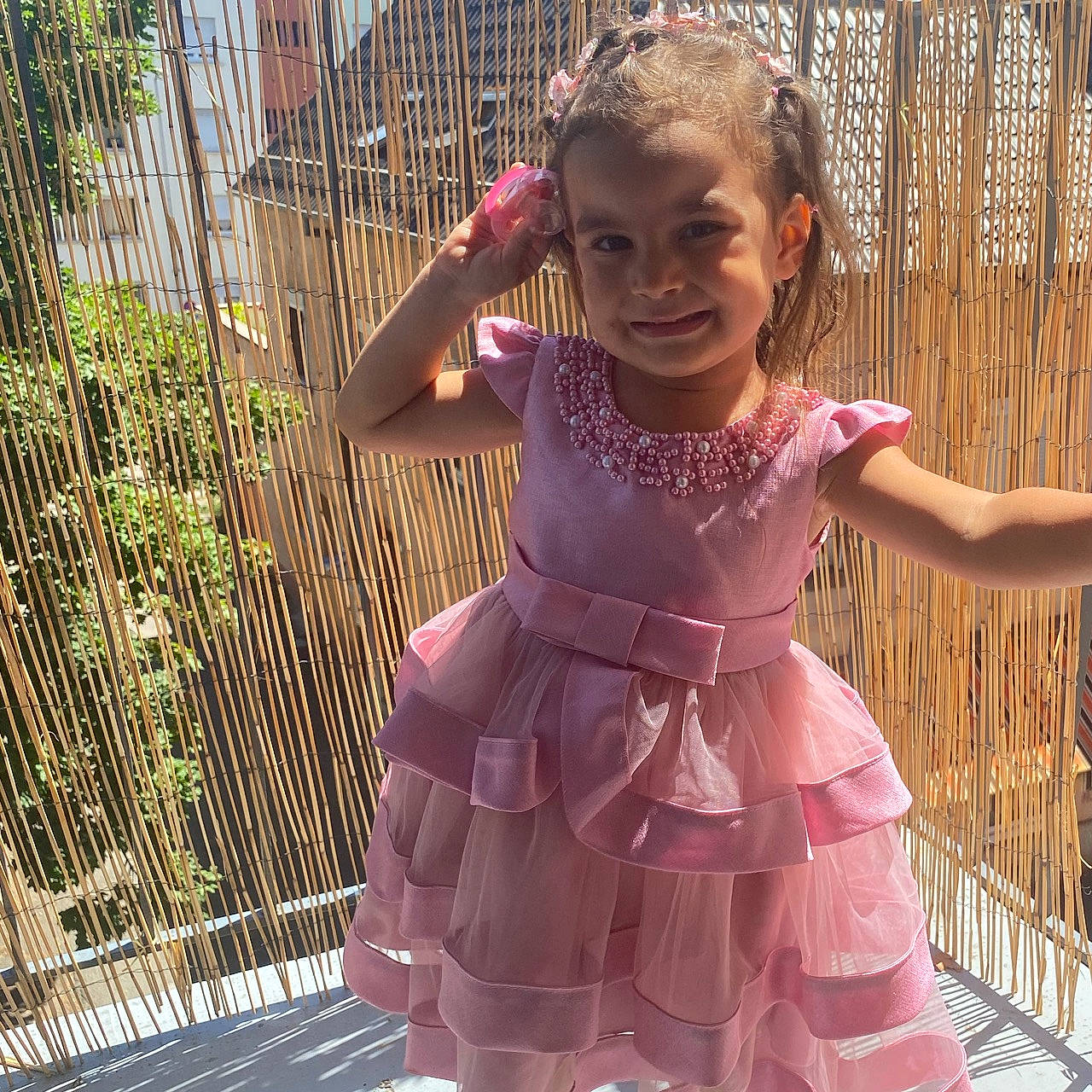Lorena participe au concours pour gagner de l'argent avec cette photo : baby_toddler_clothing, child, day_dress, dress, embellishment, event, fence, fun, hairstyle, happy, human_body, joy, magenta, mesh, person, pink, plant, purple, ruffle, sleeve