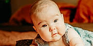 Stella is registered to the contest to win money with this photo: baby, infant, child, face, eyes, skin, arms, bed, blanket, clothing, cute, expression, indoors, light, portrait, soft, toddler, young, curious, lying_down