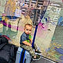 Kylian joined the competition — help win amazing prizes! toddler, child, suitcase, luggage, camo_pants, green_sneakers, backpack, reflection, store, glass_wall, artwork, lion, crown, floor, waiting, travel, indoor, person, casual_clothing, portrait
