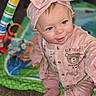 baby, child, infant, pink_outfit, headband, bow, play_mat, toy, smiling, sitting, cute, indoor, carpet, clothing, face, person, happy, portrait, baby_girl, soft_texture