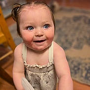 Rhaena is registered to the contest to win money with this photo: toddler, child, baby, blue_eyes, smiling, indoor, curly_hair, cloth, playful, cute, skin, dress, person, portrait, happy, standing, wooden_floor, carpet, home, young
