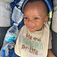 Keyvon joined the competition — help win amazing prizes! baby, smile, bib, blanket, water_bottle, child, cute, happy, person, infant, clothing, seat, car_seat, portrait, closeup, young_child, cozy, expression, face, sitting