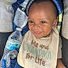 baby, smile, bib, blanket, water_bottle, child, cute, happy, person, infant, clothing, seat, car_seat, portrait, closeup, young_child, cozy, expression, face, sitting