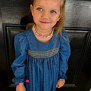 Anastasia is registered to the contest to win money with this photo: child, girl, blue_dress, necklace, smile, standing, black_door, long_sleeves, embroidery, shoes, white_socks, bracelet, outdoor, portrait, happy, cute, person, fashion, front_door, young