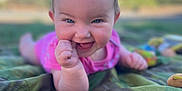 Persephone is registered to the contest to win money with this photo: baby, infant, smile, outdoor, blanket, camouflage, happy, grass, nature, child, face, skin, hand, blue_sky, daylight, person, young, cute, playful, portrait