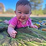 baby, child, smiling, outdoor, blue_sky, green_quilt, grass, face, portrait, infant, happy, person, nature, sunlight, clothing, lying_down, cute, cheerful, toddler, daytime