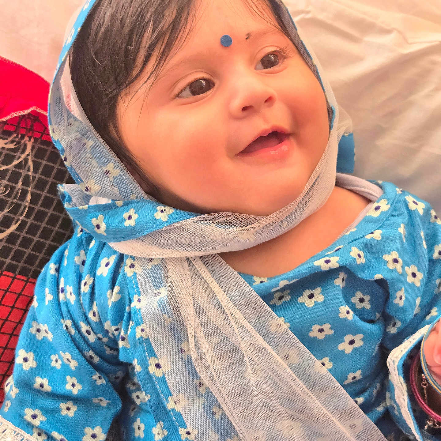 Ajeet is registered to the contest to win money with this photo: baby, bangle, blue_clothing, cheeks, child, closeup, cultural_mark, cute, face, floral_pattern, happy, headwear, indoor, infant, person, portrait, scarf, skin, smiling, soft_light