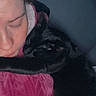 person, cat, black_cat, sleeping, cozy, close_up, indoor, cuddling, pet, animal, face, paw, blanket, resting, intimate, dark, soft_lighting, comfort, warm, snuggling
