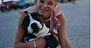 Paddle a rejoint le concours — aidez-le/la à gagner de superbes lots ! woman, dog, outdoor, pavement, hugging, black_and_white, glasses, smiling, casual_clothing, sunset, people, car, blurred_background, kneeling, friendship, pet, happy, candid, animal, leisure