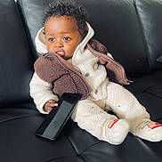 Davi a rejoint le concours — aidez-le/la à gagner de superbes lots ! toddler, child, baby, couch, leather, black, phone, smartphone, clothing, jacket, socks, curly_hair, indoor, seated, pout, cute, cozy, warm, expression, portrait