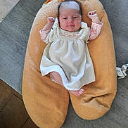 Malou participe au concours pour gagner de l'argent avec cette photo : baby, child, comfort, content, cushion, cute, fabric, feet, floor, indoor, infant, knitted, newborn, orange, peaceful, person, raised_arms, relaxed, soft, white_dress
