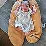 baby, child, comfort, content, cushion, cute, fabric, feet, floor, indoor, infant, knitted, newborn, orange, peaceful, person, raised_arms, relaxed, soft, white_dress
