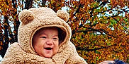 Saangshi is registered to the contest to win money with this photo: baby, child, adult, autumn, fall_leaves, tree, outdoor, smile, happy, coat, hood, bear_ears, warm_clothing, person, nature, seasonal, holding, joy, family, portrait