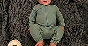 Hylandis is registered to the contest to win money with this photo: baby, blanket, bodypart, clothing, face, finger, footwear, hand, happy, head, pajamas, pants, person, photography, portrait, quilt, shoe, sitting, sleeve, smile