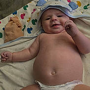 Wesley joined the competition — help win amazing prizes! baby, diaper, towel, hooded_towel, smiling, infant, child, cute, lying_down, playful, skin, face, hand, blanket, colorful, pattern, soft, indoors, happy, chubby