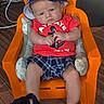 baby, child, hat, orange_chair, red_shirt, plaid_shorts, blue_shoes, indoor, carpet, toy, expression, person, face, sitting, footwear, furniture, hand, blue, casual_clothing, anchor_design