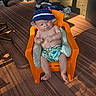 Wesley joined the competition — help win amazing prizes! baby, child, hat, shorts, orange_chair, cushions, indoor, carpet, sunlight, shadow, stroller, clothing, floor, plastic_chair, person, seated, comfort, casual, home, relaxation